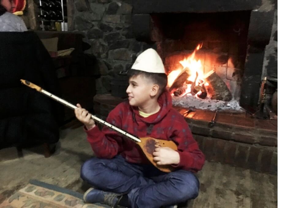 Albanees jonge man speelt op zijn 'çifteli', karakteristiek instrument voor het noorden van Albanië