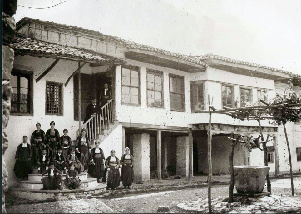 Het geboortehuis van Pashko Vasa eind negentiende eeuw. De hele familie poseert met de pater familias (2e van rechts) op de trap. Fotograaf Pjetër Marubi.