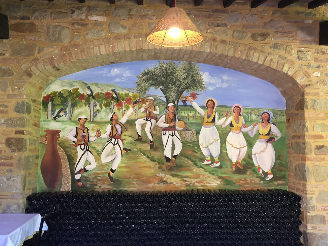 Muurschildering in Kantine Korriku. Danser in de klederdracht van regio Midden-Albanië.