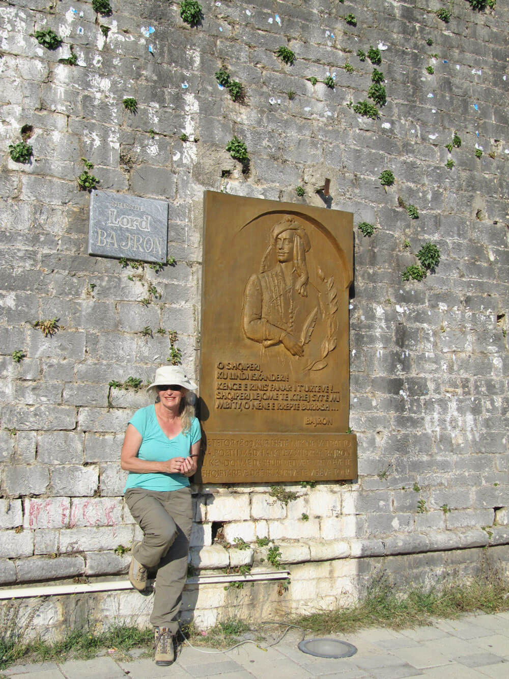 Tessa voor de muur van het oude kasteel voor plaquette Byron.