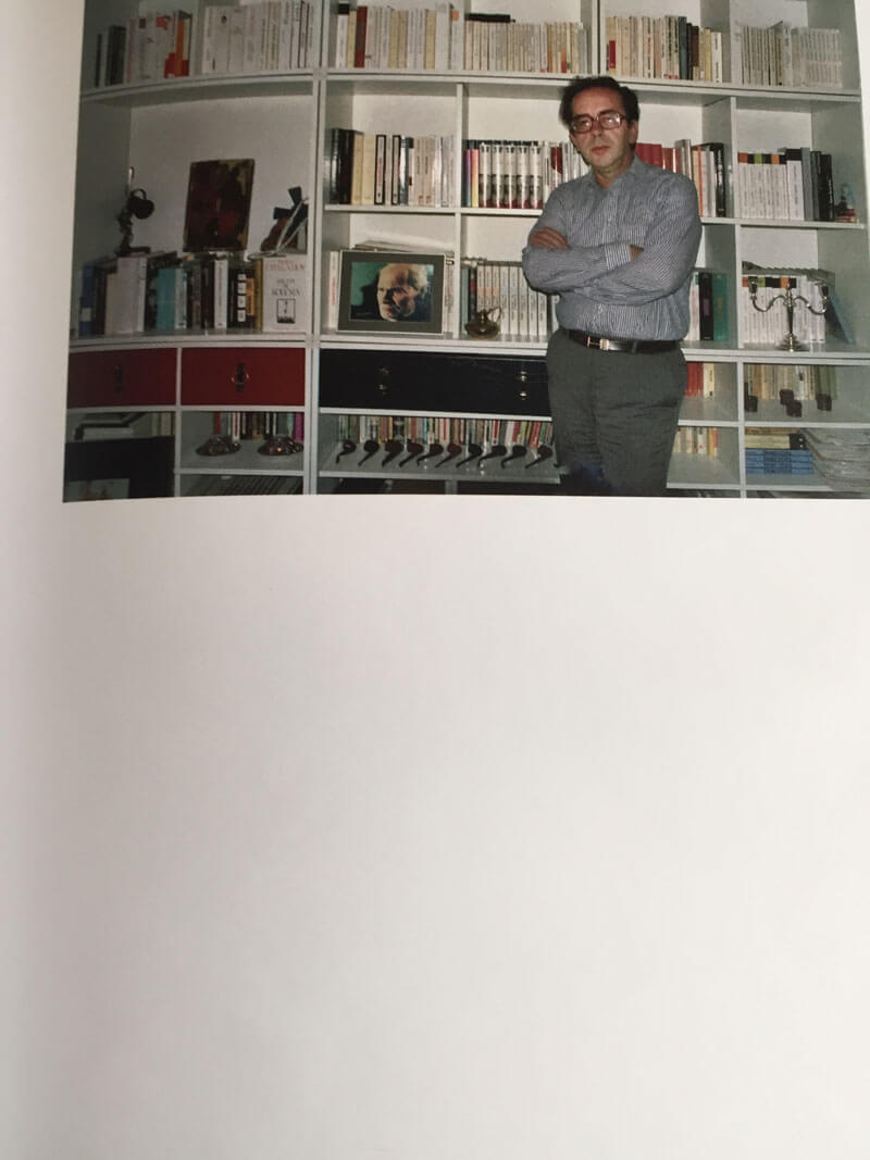 Ismail zelf op de foto; voor zijn boekenkast in studiohuis in Tirana.