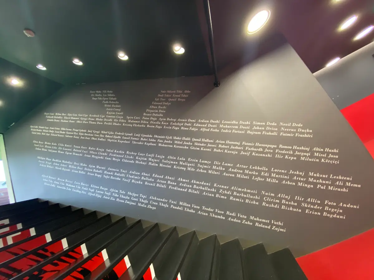 Een zwarte trap met tekst op de antracietgrijze muur bij het Air Albania Stadion.