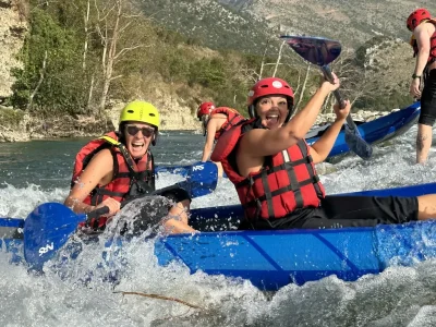 Twee lachende personen in een kajak op de Osumi rivier.