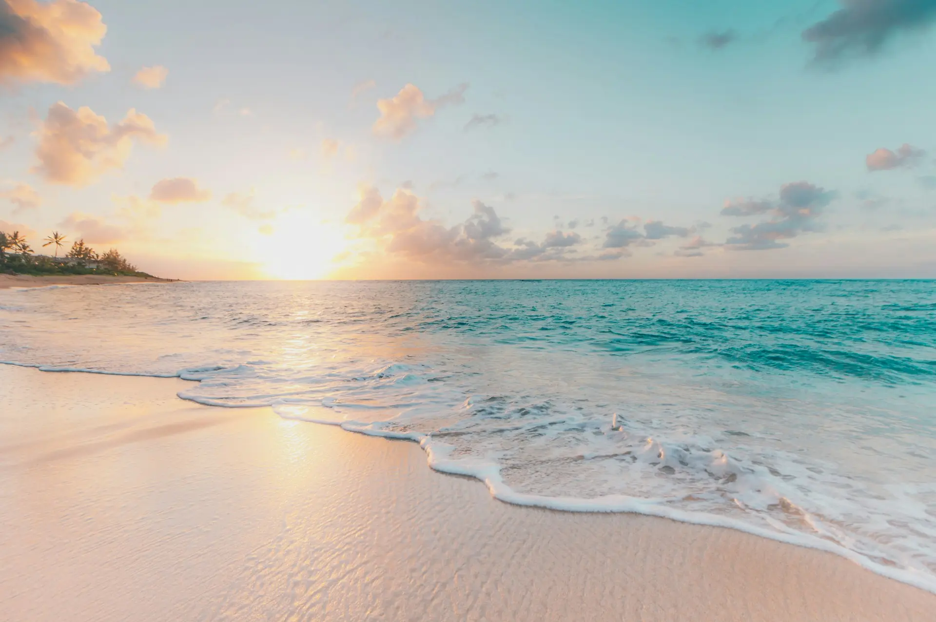 Een prachtig strand met helder blauw water en een zonnetje.