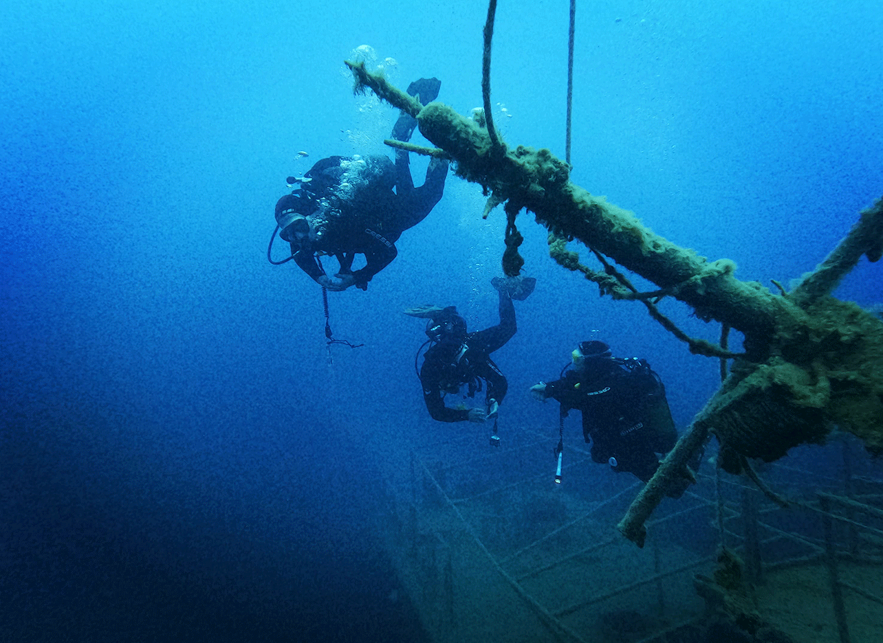Duikers dalen af langs het mast van een scheepswrak in Palasë.