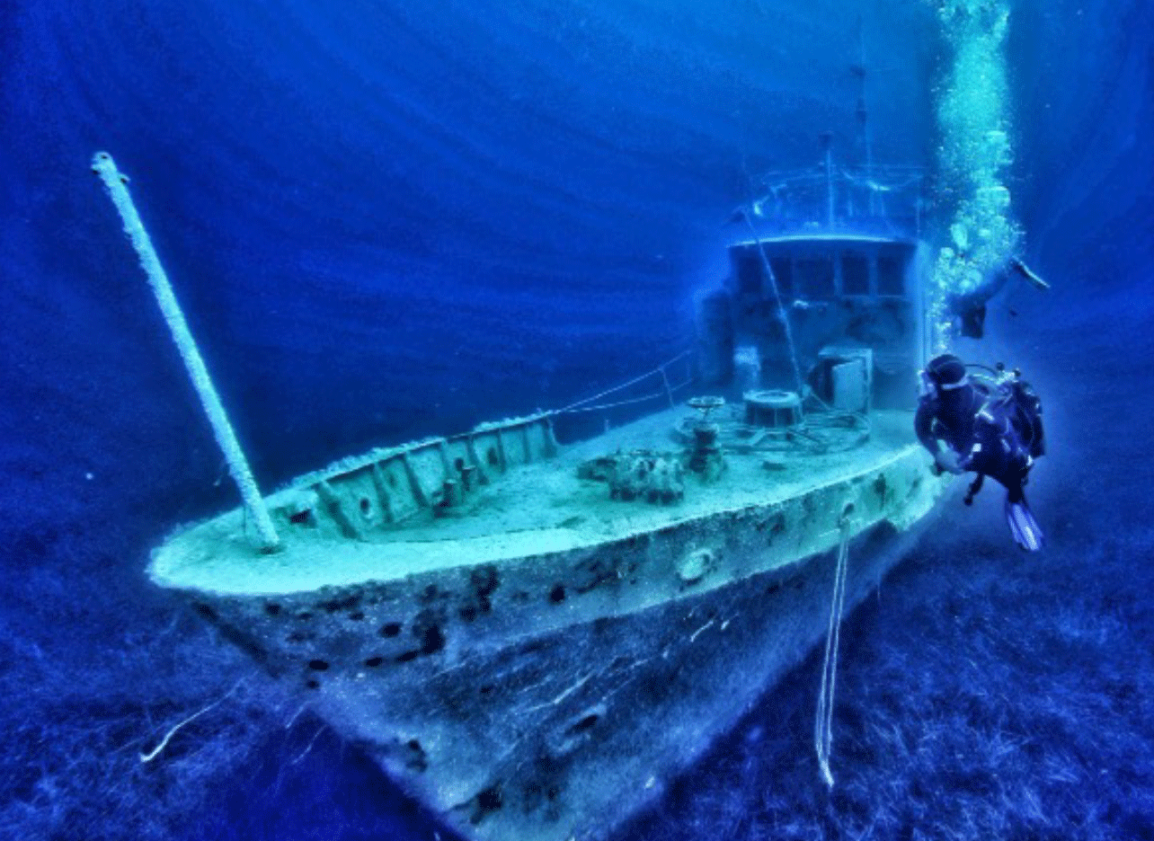 Het wrak van de Polumbari op de zeebodem van Palasë met duikers eromheen