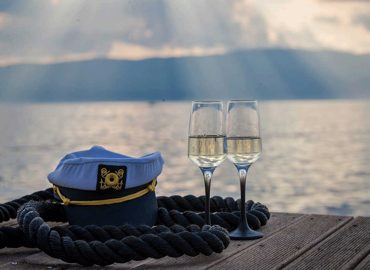 Twee glazen champagne op het dek met uitzicht over het meer.