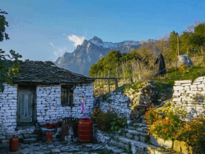 Traditioneel stenen huis in een dorp van Zagoria met hoge bergen op de achtergrond.