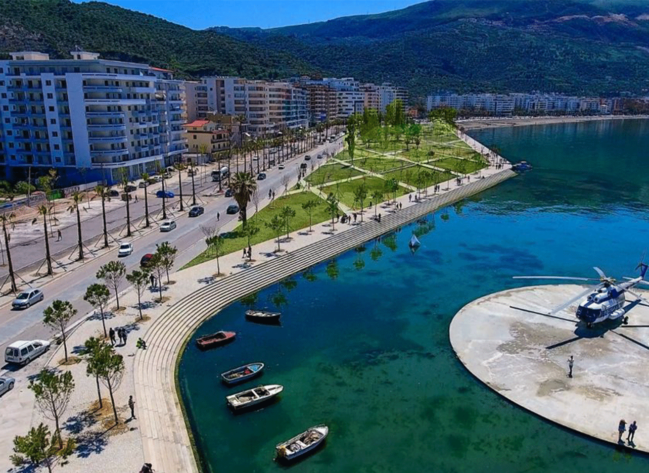Luchtfoto van de boulevard in Vlora met palmbomen, groen park en blauwe zee.